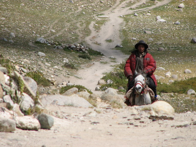 Tibetan man riding a horse around the last part of the curcuit circling Kailash.